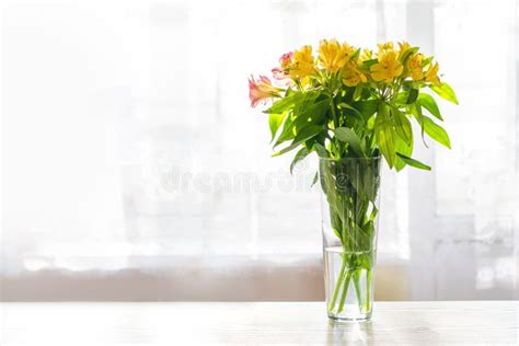 Flores En Un Jarrón De Vidrio Sobre La Mesa Luz Solar En El Fondo