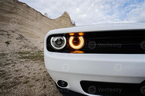 Round headlights of white powerfull american muscle car in career ...