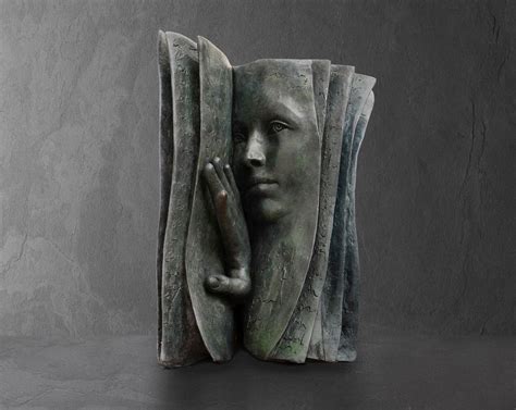 Pensive Faces Peer Out From The Pages Of Bronze Book Sculptures By