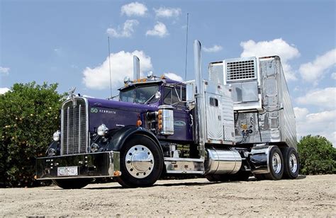 A Large Semi Truck Parked On Top Of A Dirt Field