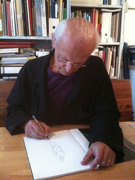 An Older Man Sitting At A Table Writing On Paper