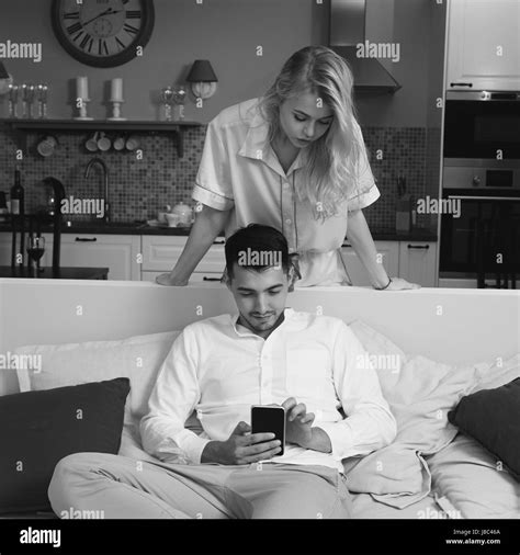 Handsome Brunette Man Sitting At Sofa And Using Smartphone Pretty Beautiful Caucasian Girl With