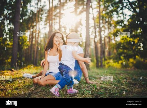 Los padres jóvenes se les enseña a caminar a su hija de un año en la