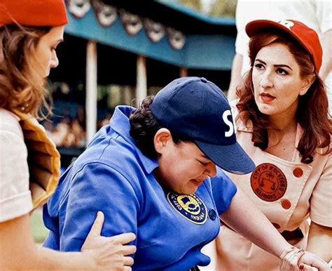 Two Women In Baseball Uniforms And One Is Touching Another Woman S Hand