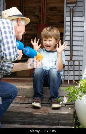 Grand P Re Et Petit Enfant Appr Ciant Dans Le Jardin Avec Des Fleurs De