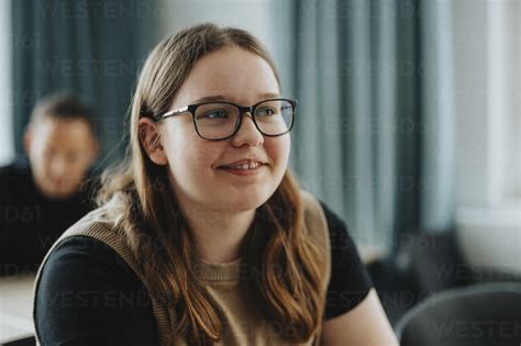 smiling teenage girl  long brown hair wearing eyeglasses  high
