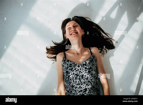 Carefree Brunette Woman Lying On The Floor Laughing Stock Photo Alamy