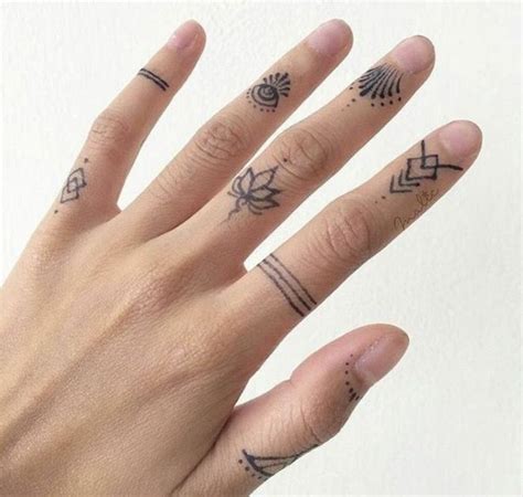 A Woman S Hand With Tattoos On It And Two Fingers In The Foreground