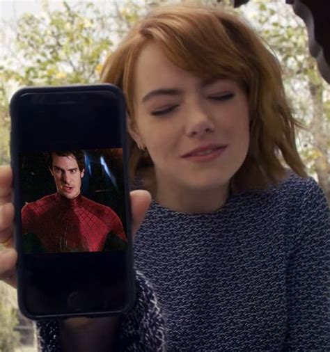 A Woman Holding Up A Cell Phone With An Image Of Spider Man On It