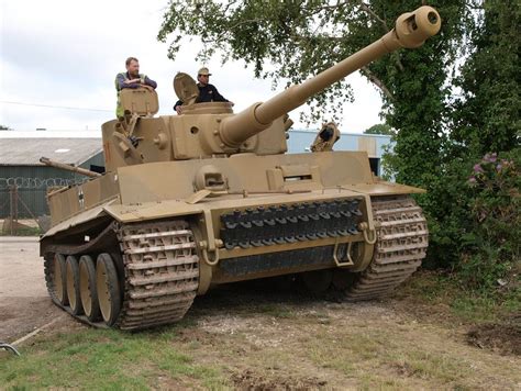 Two Men Are Sitting On Top Of A Tank