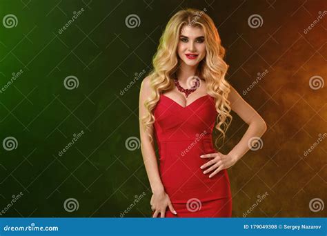 Blonde Woman With Alluring Decollete In Red Fitting Dress And Necklace Smiling Hand On Waist