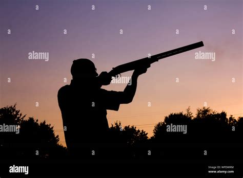 Silueta Hombre Escopeta Apuntando Contra El Cielo Despejado Durante La