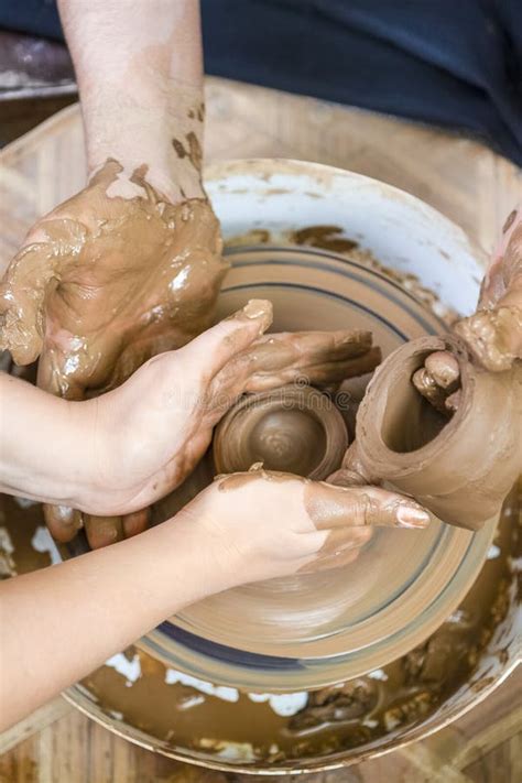 Potter Working With Female Apprentice Working With Clay Lump On Potter