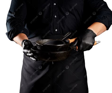 A Man Dressed In A Black Chefs Uniform And Wearing Latex Gloves Holds