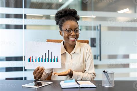Smiling businesswoman showing financial chart during office meeting