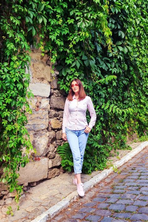 Una Ragazza Magra In Bikini Viola In Posa Con La Schiena Rivolta Verso Una Telecamera Vicino Al