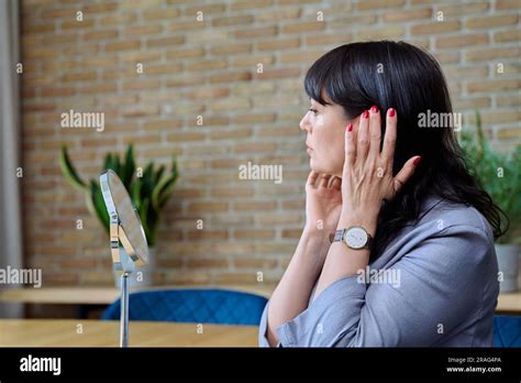 Mature Woman Admiring Her Face In Mirror Touching Skin With Hands Stock Photo Alamy