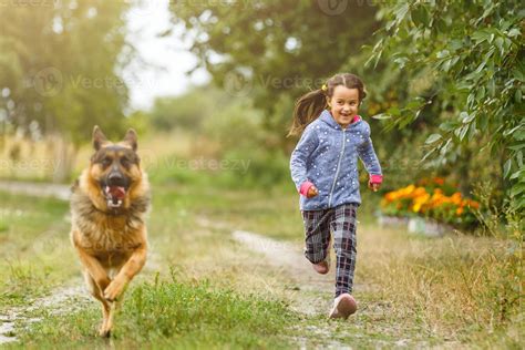 Pretty little girl, Gives a command to sit to german shepherd dog