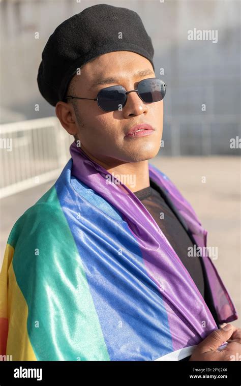 Gay Man With Make Up On Under LGBT Rainbow Flag While Looking At Camera Concept Of Pride Pride