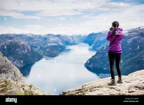 Nature Photographer Tourist With Camera Shoots While Standing On Top Of