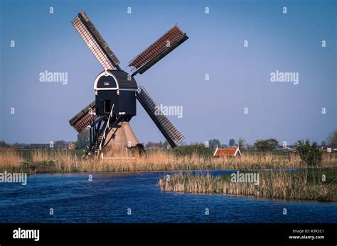 Typical Dutch Polder Landscape With Traditional Windmill Against Blue