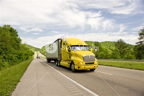 Yellow Semi Truck Travels On Interstate In Springtime Royalty-Free Stock Image - Storyblocks