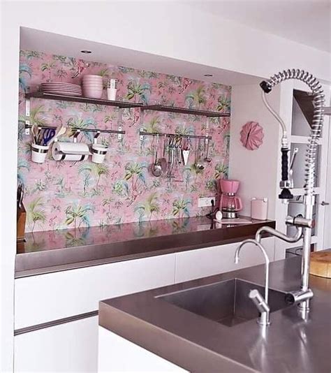 A Kitchen With Pink Wallpaper And Stainless Steel Counter Top Sink And