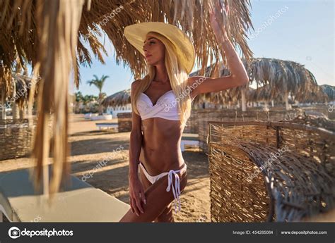 Sexy Woman Wearing Bikini Standing Under Straw Canopy Umbrella At The