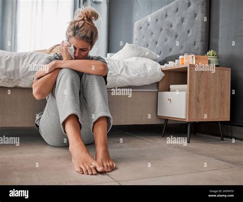 Crying Sad And Depressed Woman On Bedroom Floor Using Wipe For Tears Struggling With Mental