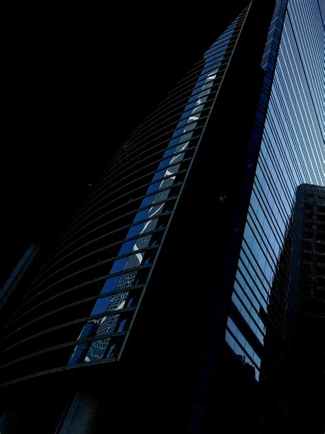 Modern skyscraper with glass walls at night · Free Stock Photo