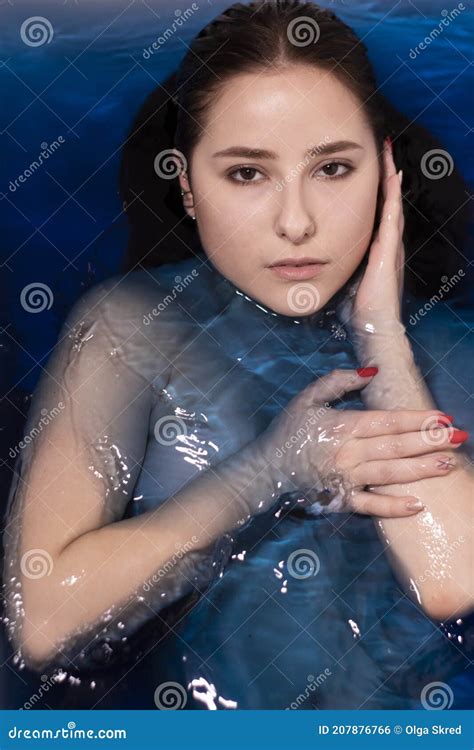 Portrait Of Attractive Brunette Woman Topless In Blue Liquid In