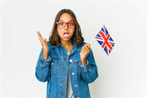 Joven Latina Sosteniendo Una Bandera Inglesa Aislada En Blanco Recibiendo Una Agradable Sorpresa
