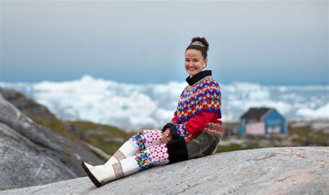 Young Inuit Woman In Traditional Clothing Posing For Photos In A Small