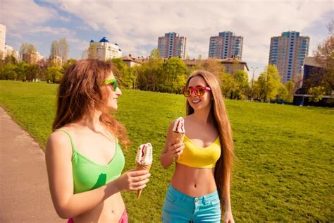 Atractivas Mujeres Sexy Felices Caminando En El Parque Y Comiendo Helado Foto Premium