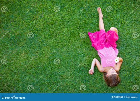 Stock Image: Top view of little girl lying on grass. Image: 9813551