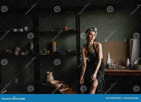 Beautiful Sculptor Girl With Bandage On Her Head And A Black Apron On