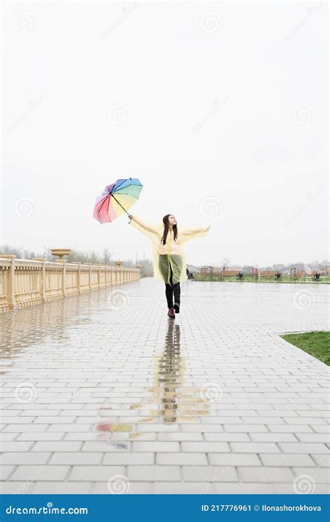 Beautiful Brunette Woman Holding Colorful Umbrella Walking In The Rain