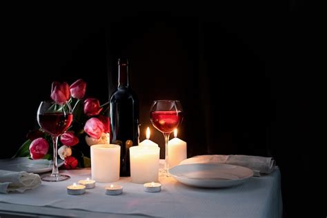 Jantar Romântico à Luz De Velas Com Vinho Velas E Buquê De Tulipas Foto Premium