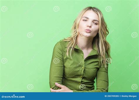 Winsome Caucasian Blond Girl In Green Shirt Posing In Shorts While Looking Straight With Kiss