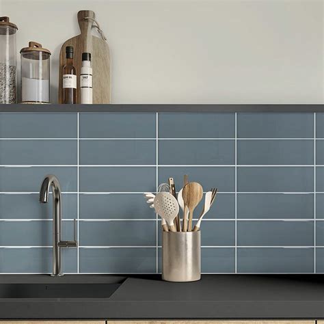 A Kitchen Counter With Utensils In A Metal Cup On Top Of The Sink