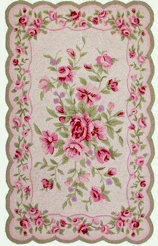 A Rug With Pink Flowers And Green Leaves On The Bottom In Front Of A