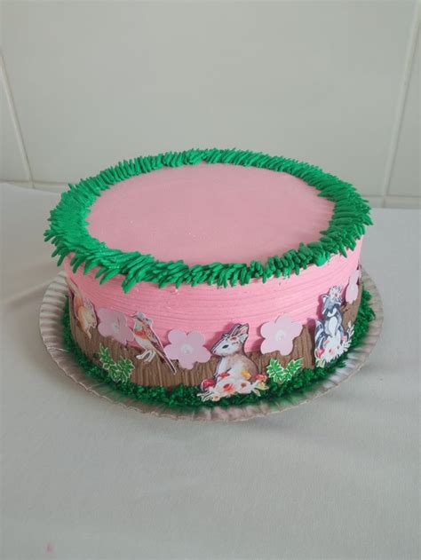 A Pink And Green Decorated Cake Sitting On Top Of A Table