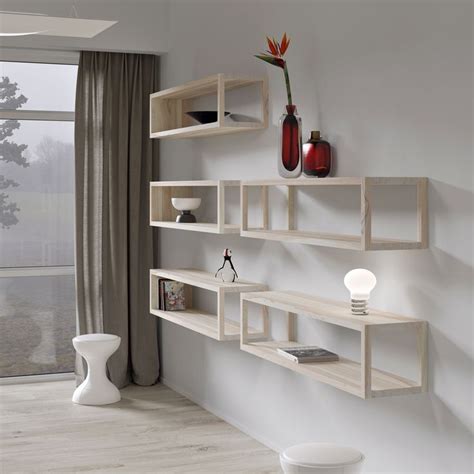 a white room with some shelves and vases on the wall next to a window