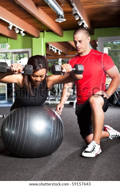 Shot Male Personal Trainer Assisting Woman Stock Photo