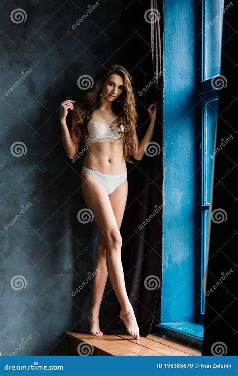 Beautiful Woman In Lingerie Showing Long Legs Pose Standing At Bed Over
