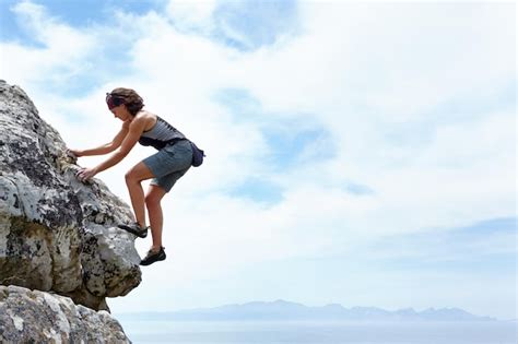 No hay montaña demasiado alta una mujer escalando una roca en un día