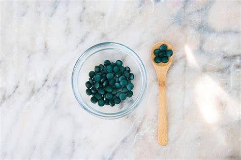 Premium Photo Spirulina Tablets In A Glass Bowl And A Wooden Spoon On