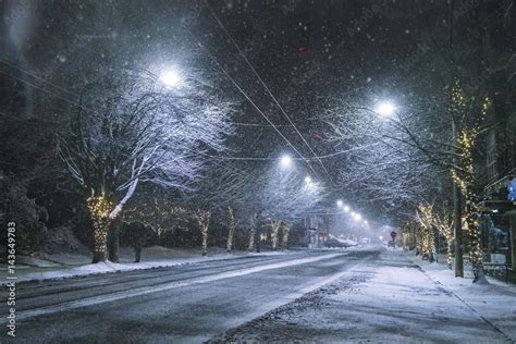 snowy road at night in downtown in winter season. Stock Photo | Adobe Stock