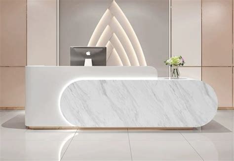 A White Marble Reception Desk In A Modern Office Setting With Flowers