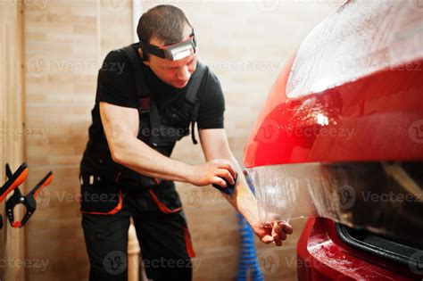 Le Travailleur Du Service Automobile A Mis Un Film Anti Gravier Sur Une